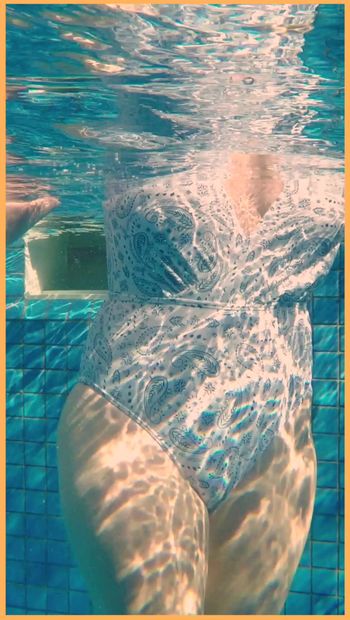 Vrouw toont haar tieten in het zwembad van het hotel.