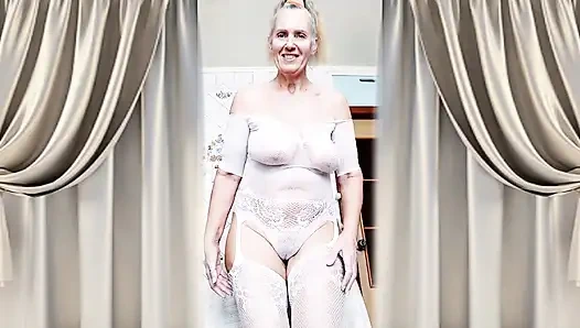 Hot housewife Lukerya flirts in an open transparent white jumpsuit in the kitchen.