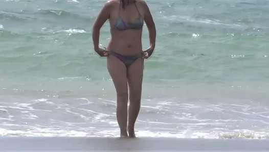 Une femme mature poilue s'exhibe sur la plage en se masturbant