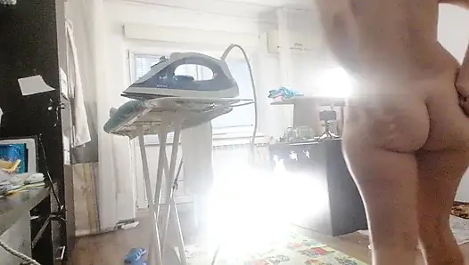 Sexy brunette doing naked chores around the house.