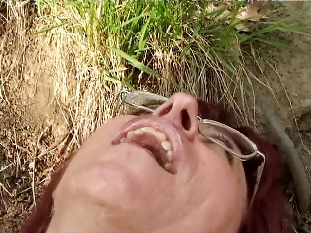 लाल बालों वाली परिपक्व बेतहाशा लकड़ी में पटक दी गई