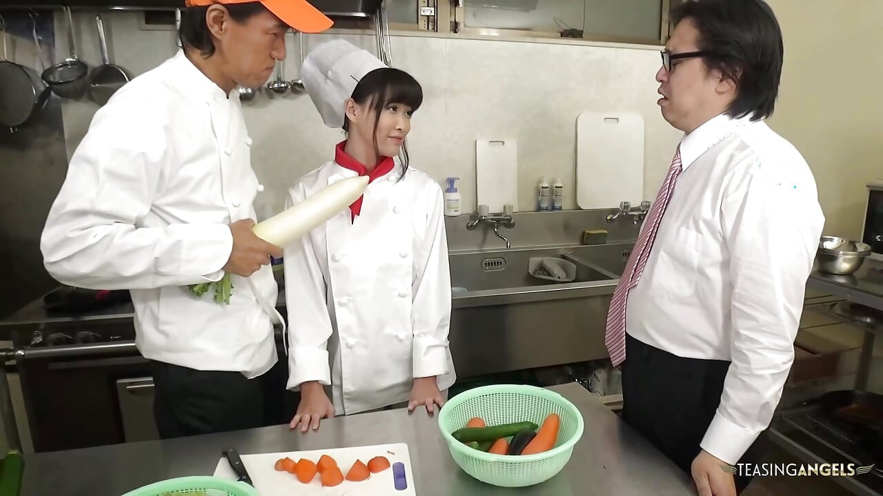 O chef e a gerência do restaurante repreendem o cozinheiro asiático instruindo-a a apertar vegetais grossos