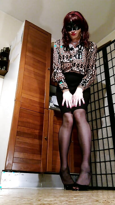 Posing in sexy black mules, mini skirt and black stockings