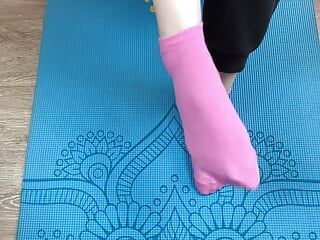 Fitness girl does exercises on the mat in socks and gives a footjob to her trainer with cum on her feet