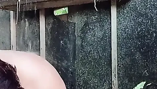 I'm watching a curvy girl wash herself in the street.