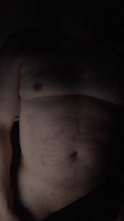 A naked man looks in the mirror.