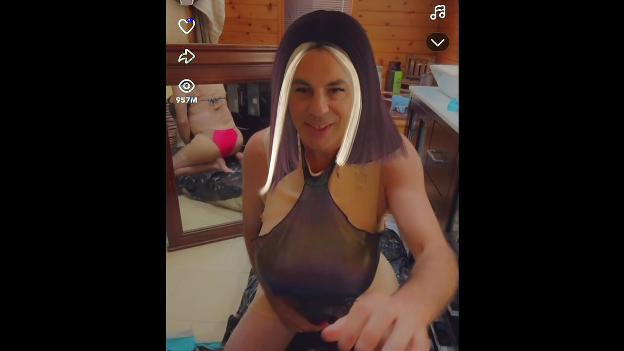O transsexuală sexy poartă un blug metalic lucios în timp ce se masturbează