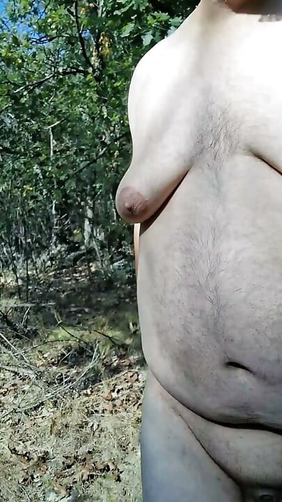 Chubby guy strips, leaves clothes behind and cums in the woods
