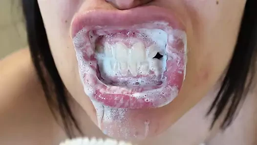 Eu escovo meus dentes e muito creme branco entra na minha boca