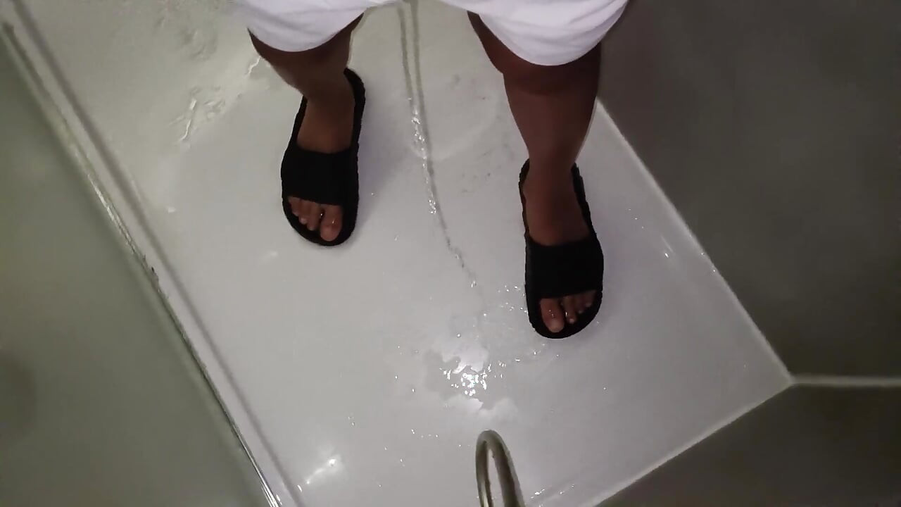 Piss på føttene i sandaler Slides mens du har på deg hvite badebukser