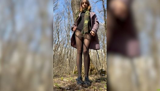 Une fille mince et coquine en collants en nylon se masturbe dans la forêt