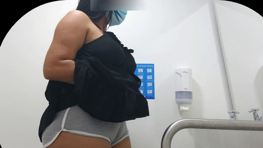 Une caméra capture le cameltoe d'une fille avec un gros cul dans des toilettes publiques