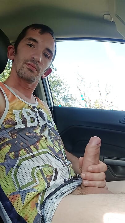 Um jovem goza com o pau grande dentro do carro