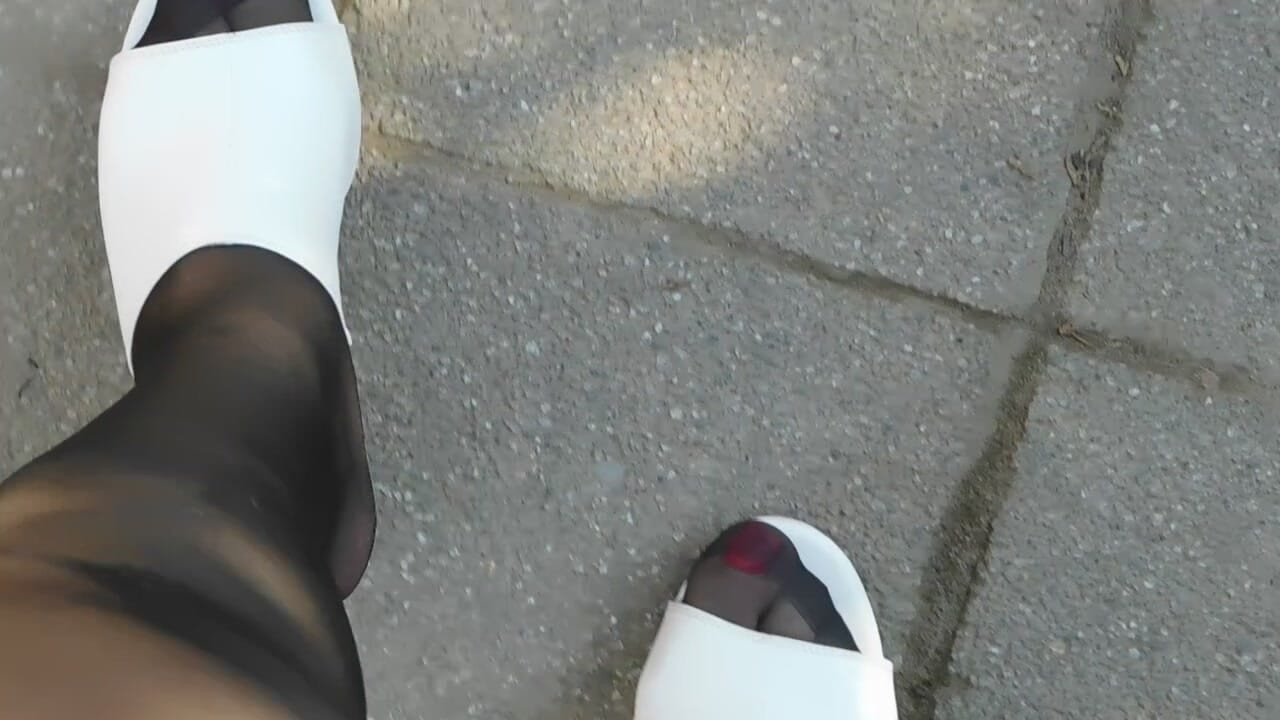White mules and brown tights in the garden