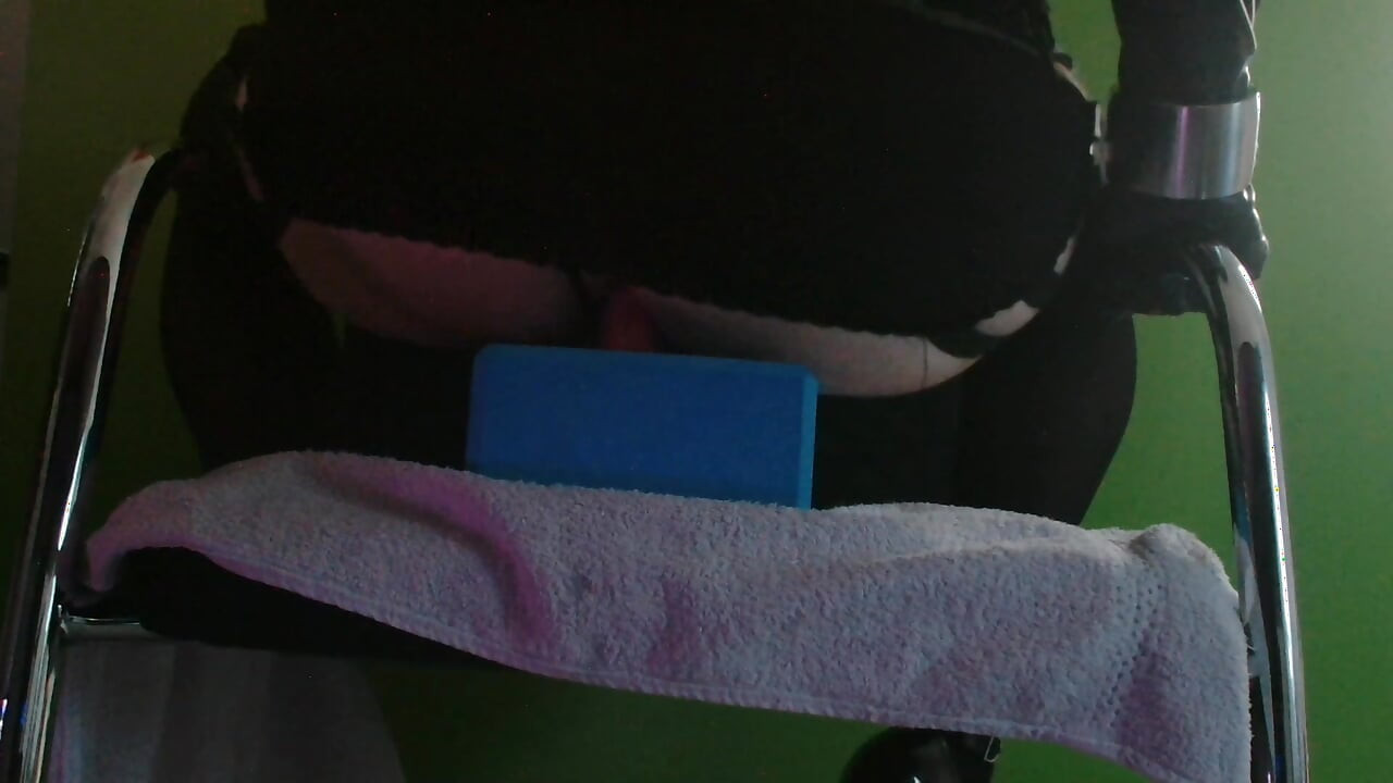 Riding 22 cm long dildo on chair in latex and heels.