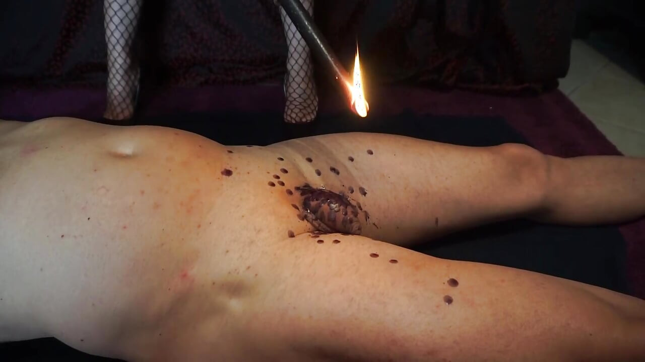 Meesteres straft zijn pik en lichaam met een was