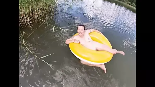 Naakt spelen met een waterdoughnut in het meer