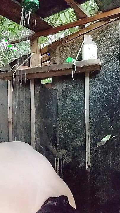 I'm watching a curvy girl wash herself in the street.