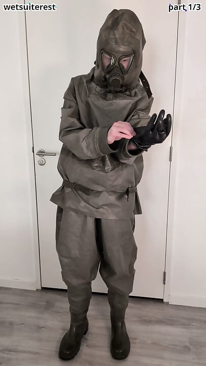 Putting on Zodiac Zodiak heavy rubber hazmat suit over plastic pants and gas mask