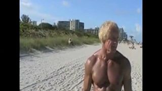 Een oudere man toont een grote blanke pik aan een naaktstrand