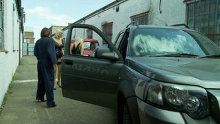 Un étalon baise une brune sexy dans un garage