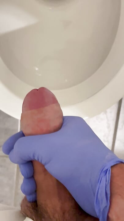Doctor is jerking off with latex gloves at a toilet in Hospital