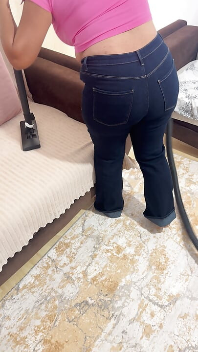 Curvy woman cleaning the house in trousers