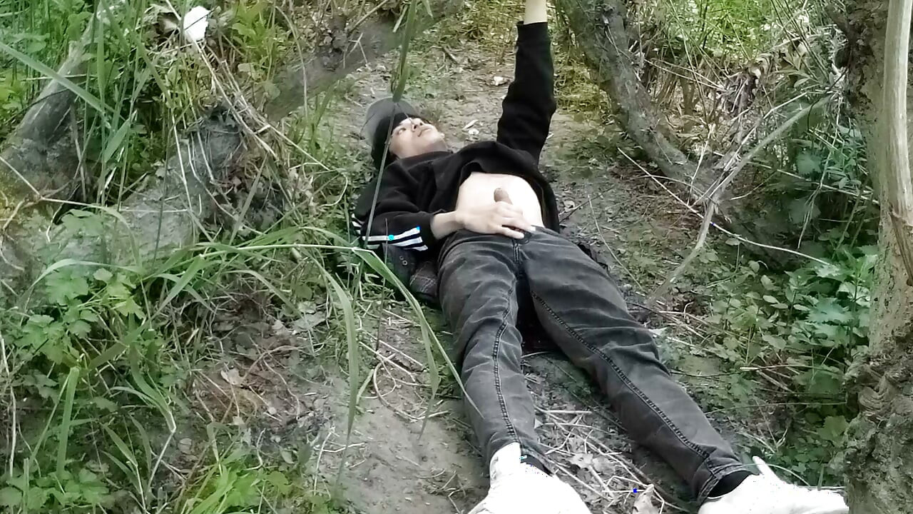 This gay twink sticks his cock through his fly to jerk off outside
