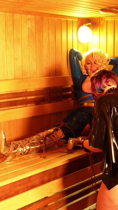 Bondage process in the sauna: sexy gagged submissive MILF in latex and her rubber dominatrix