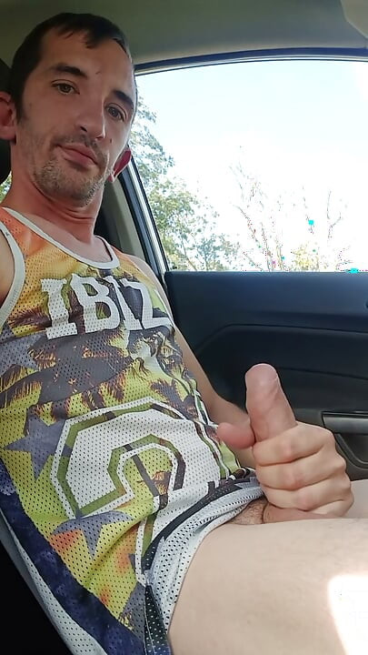 Um jovem goza com o pau grande dentro do carro
