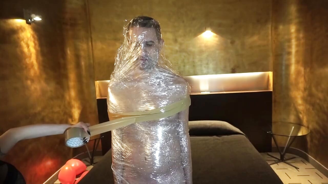 Kvinnlig dominansflicka sätter sin slav i tejp bondage