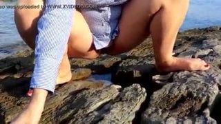 Wife pees outdoor on the beach