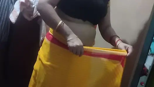 Ibu rumah tangga India mengenakan saree kuning.