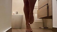 Prachtig visioen van de mooie voeten tijdens de badkamertijd gigi met een leuke en grote verrassing onder het ondergoed