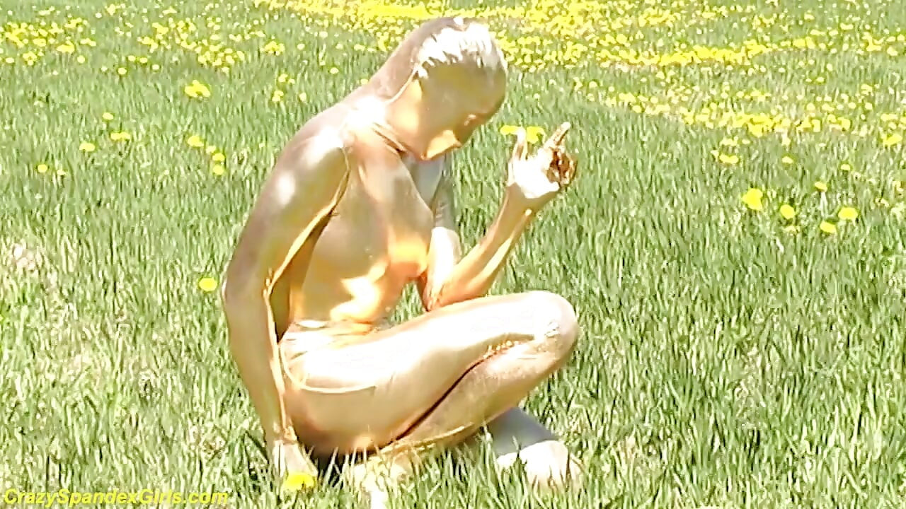 Sexy ragazza ebano in tuta di spandex dorata magra posa all'aperto