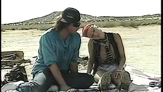 Lusty slut in leather gear rides a young stud dick in desert