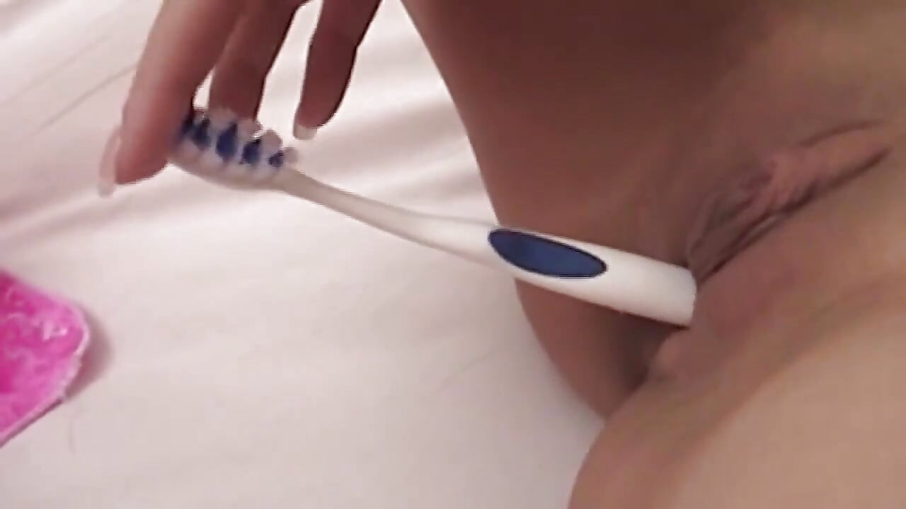 Babe plaagt poesje met tandenborstel in roze lingerie