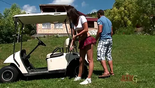Adolescente sexy aprende a jugar al golf con un gran club