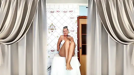 Real home solo of a mature woman in a small cozy kitchen.