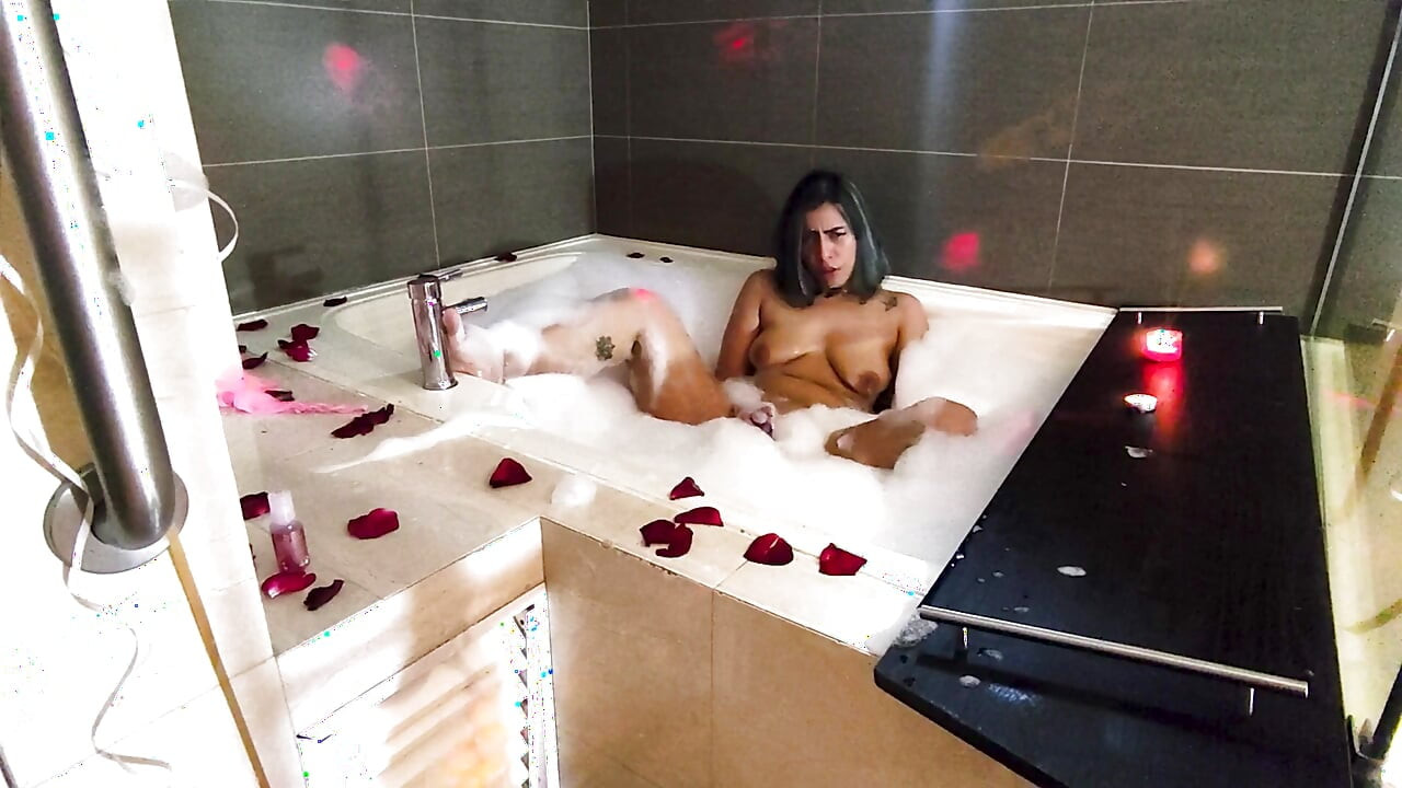 Thủ dâm lãng mạn và ướt át trong bồn tắm cho bạn, với bọt và cánh hoa hồng.