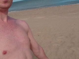 Dad walking alone on beach naked