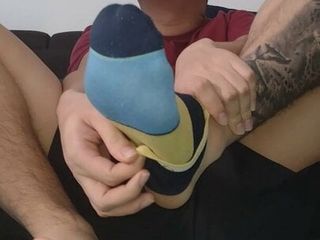 Latino shows his bare feet while watching TV