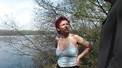 Redhead German lady gets her mouth filled near the lake