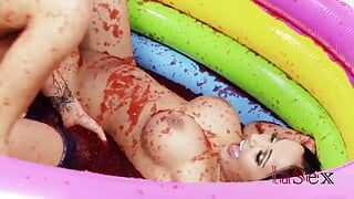 Romana Ryder & Tammia Lee in a pool full of strawberry jelly