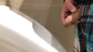 Polla sin cortar meando en los urinarios