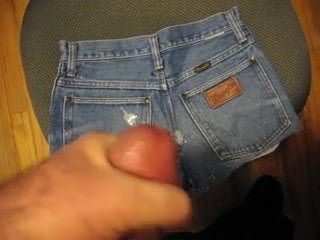 Éjacule sur un short en jean rétro en regardant du porno.