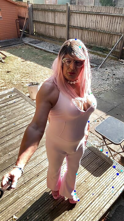 Crossdresser kellycd2022 u ružičastom kombinezonu i štiklama