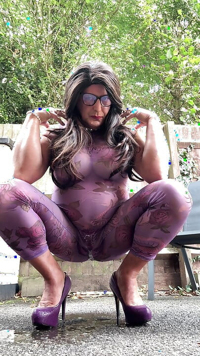 Seksi transvestit kellycd2022 u ljubičastom catsuitu i štiklama na otvorenom