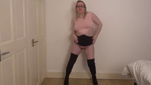 Roupa de mulher bonita em striptease com botas de coxa