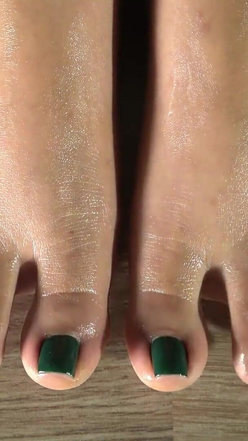 Cleaning her feets with a damp cloth and showing her green feet fingernails. Close up | Clip 3